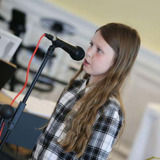Young girl singing on microphone