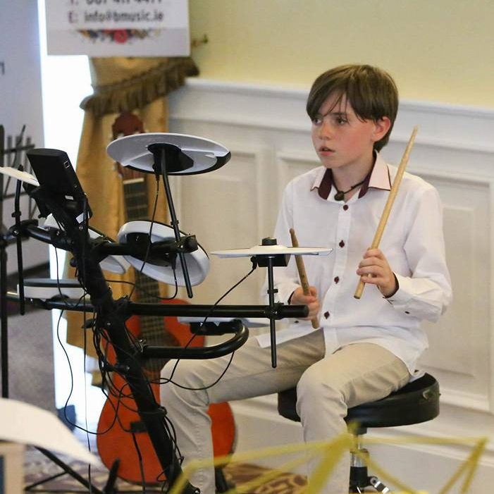 Young boy learning how to play the drums